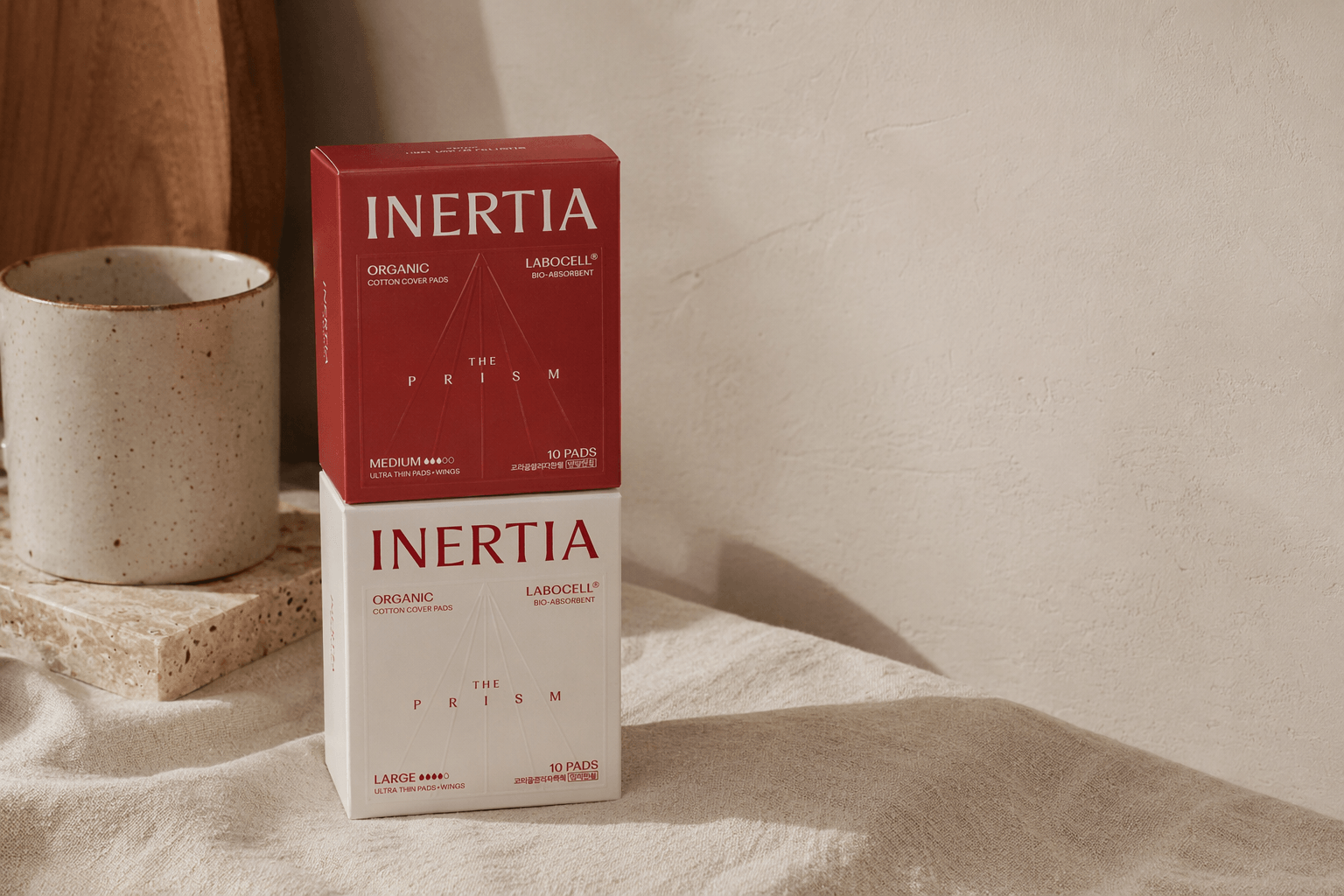 Organic cotton pads, pantyliners, inositol, and feminine wash arranged for daily cycle care.